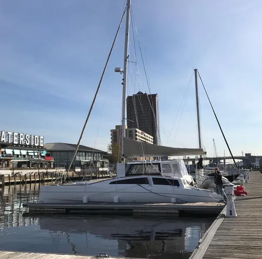 Surfer Girl Yacht Photos Pics 2018 Maine Cat 38 LS catamaran docked at a marina with cityscape background.