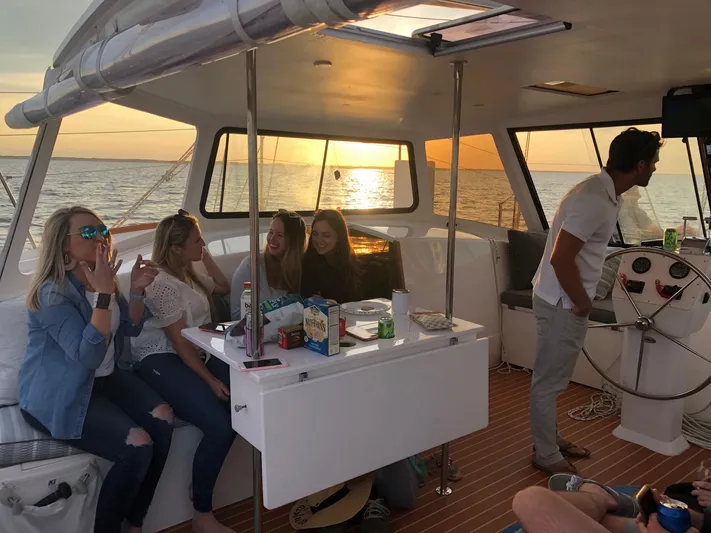 Surfer Girl Yacht Photos Pics Group enjoying sunset on 2018 Maine Cat 38 LS yacht, with snacks and drinks.
