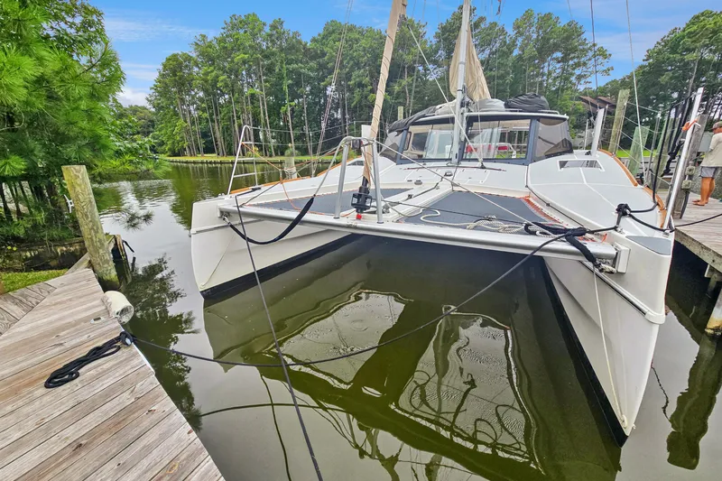 Surfer Girl Yacht Photos Pics 2018 Maine Cat 38 LS catamaran docked in a serene, wooded marina setting.