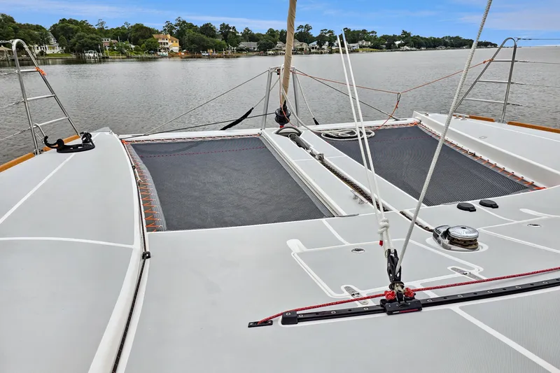 Surfer Girl Yacht Photos Pics 2018 Maine Cat 38 LS catamaran deck with netting, moored on a calm river.