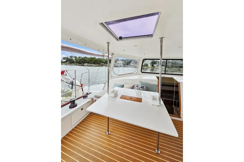 Surfer Girl Yacht Photos Pics 2018 Maine Cat 38 LS interior with table, windows, and scenic water view.