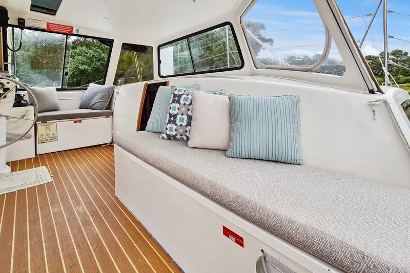 Surfer Girl Yacht Photos Pics Interior of 2018 Maine Cat 38 LS with cushioned seating and striped pillows.