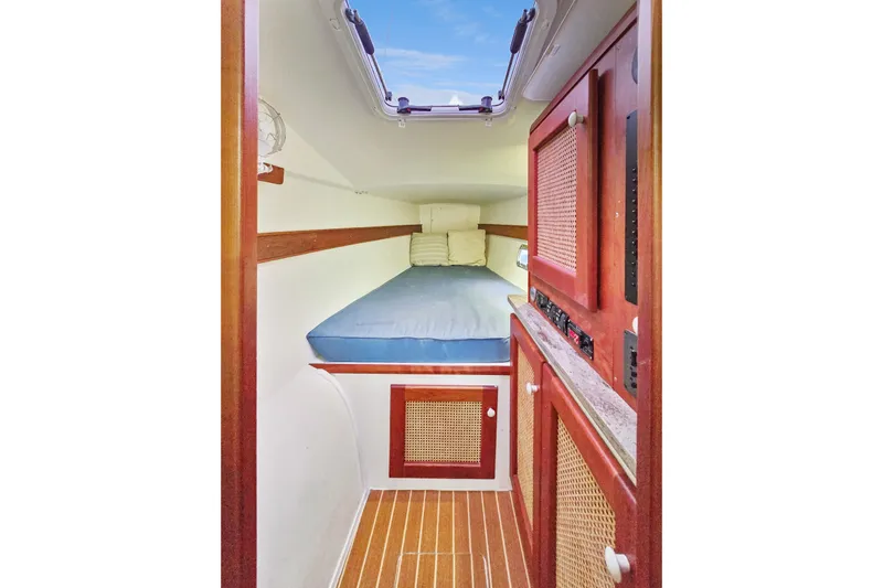 Surfer Girl Yacht Photos Pics 2018 Maine Cat 38 LS cabin interior with wooden cabinetry and blue bedding.