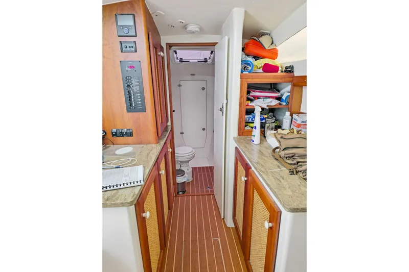 Surfer Girl Yacht Photos Pics 2018 Maine Cat 38 LS interior with wooden cabinetry and compact bathroom.