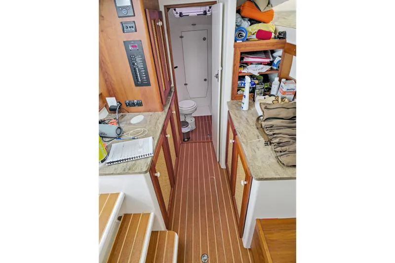 Surfer Girl Yacht Photos Pics 2018 Maine Cat 38 LS interior with wood flooring, cabinets, and a compact bathroom.