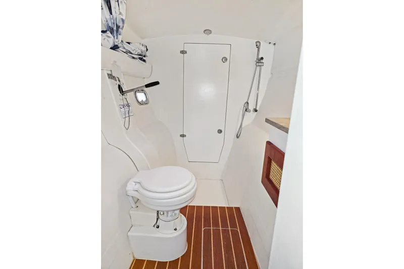 Surfer Girl Yacht Photos Pics 2018 Maine Cat 38 LS boat bathroom with toilet, shower, and wooden floor.