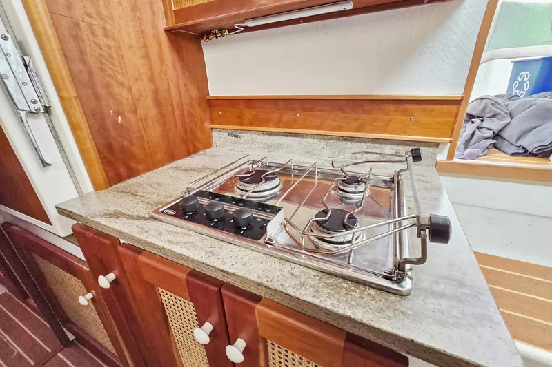 Surfer Girl Yacht Photos Pics 2018 Maine Cat 38 LS yacht kitchen with two-burner stove and wooden cabinetry.