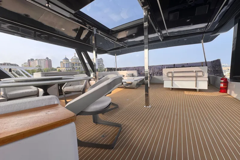  Yacht Photos Pics Luxurious deck of 2024 Mazarin 55 Catamaran Hybrid with modern seating and cityscape view.