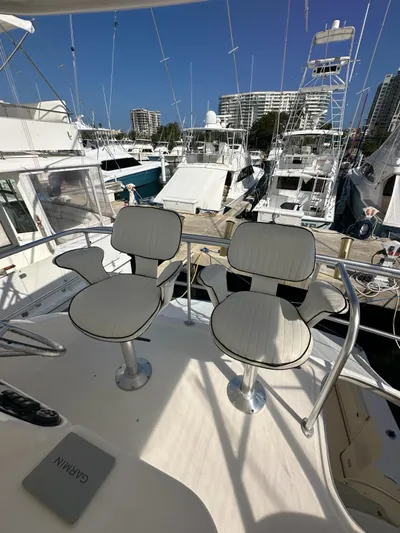  Yacht Photos Pics Two chairs on the deck of a 2003 Riviera 40 Convertible yacht in a marina.