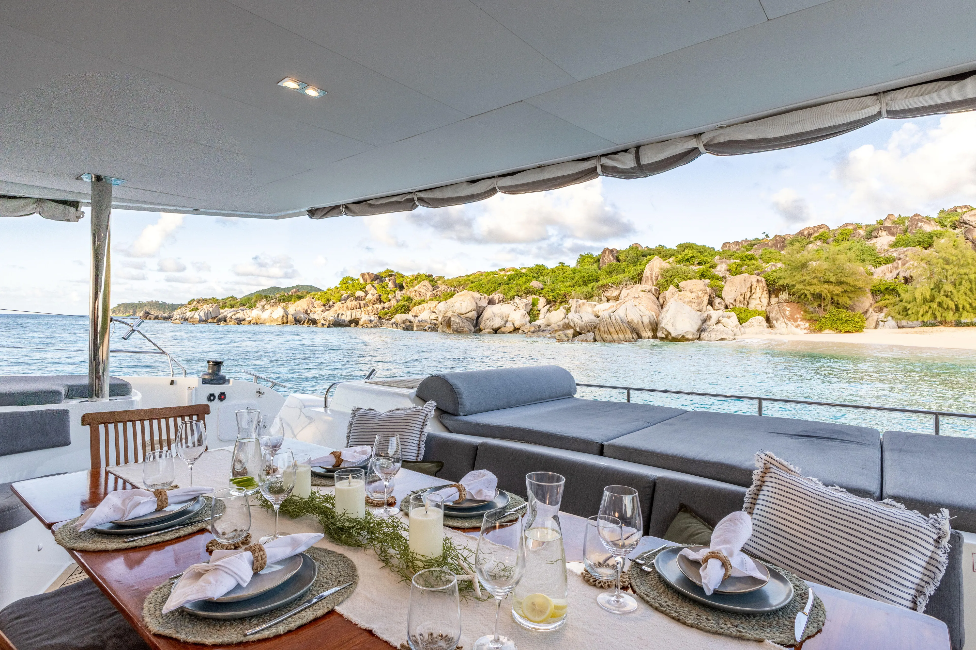  Yacht Photos Pics Luxurious dining setup on 2017 Fountaine Pajot Victoria 67 yacht, overlooking serene coastal scenery.