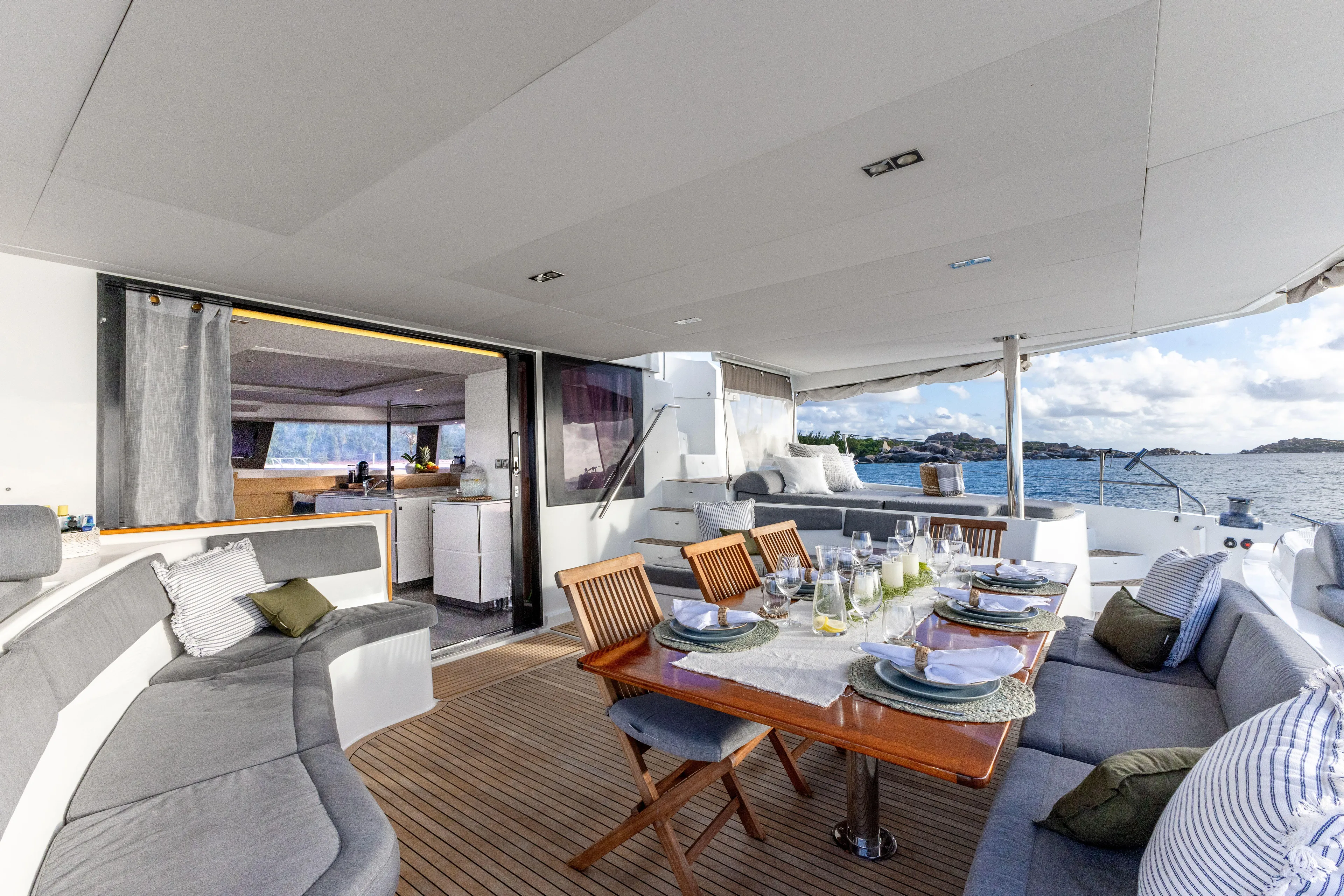  Yacht Photos Pics Luxurious 2017 Fountaine Pajot Victoria 67 yacht with elegant outdoor dining area and ocean view.
