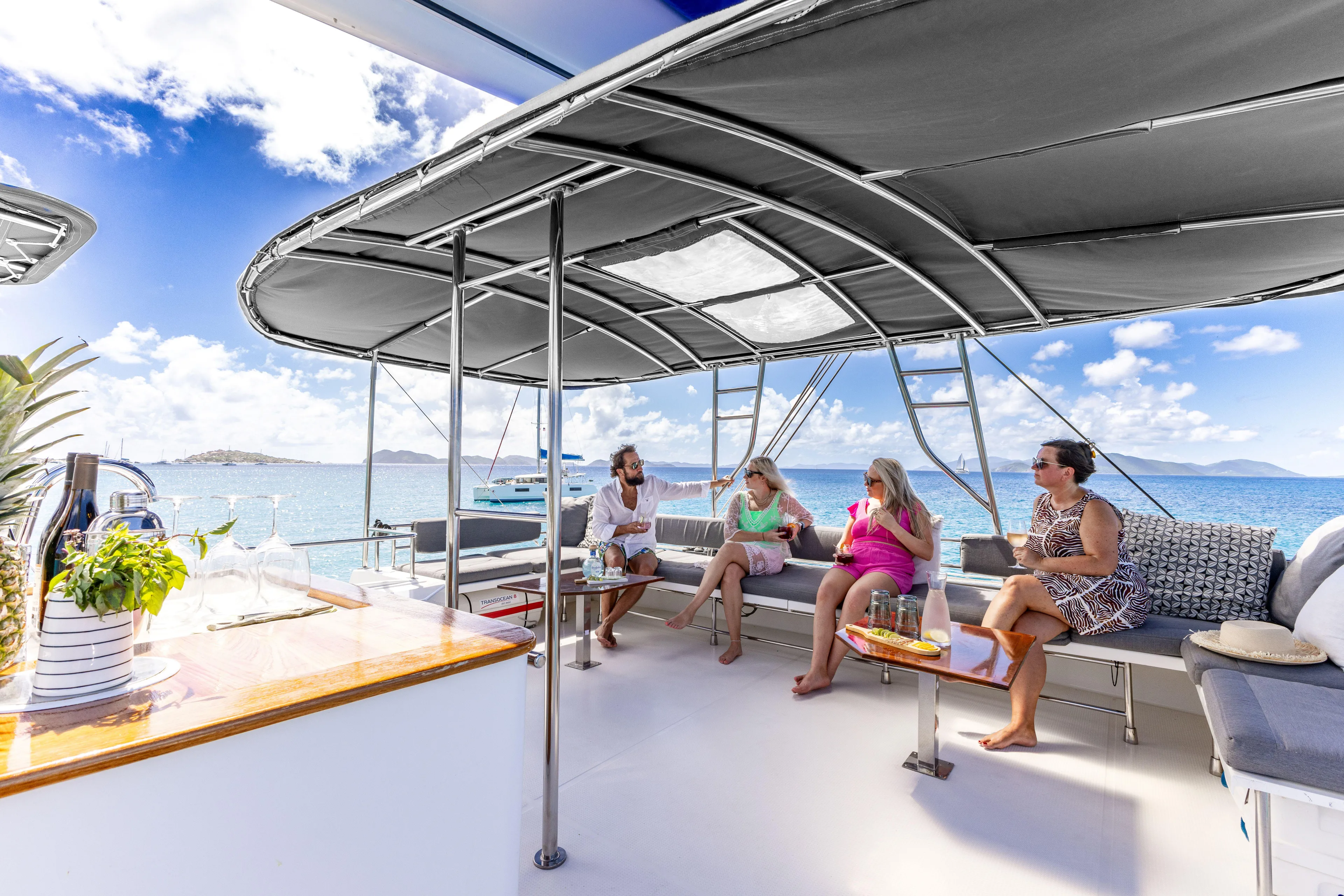  Yacht Photos Pics Four people relaxing on a 2017 Fountaine Pajot Victoria 67 yacht deck.