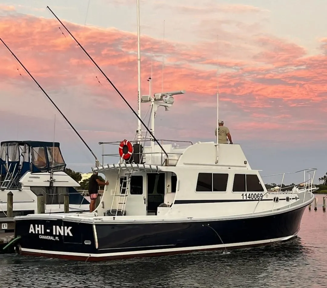 2003 Wesmac Flybridge boat docked at sunset with vibrant sky.