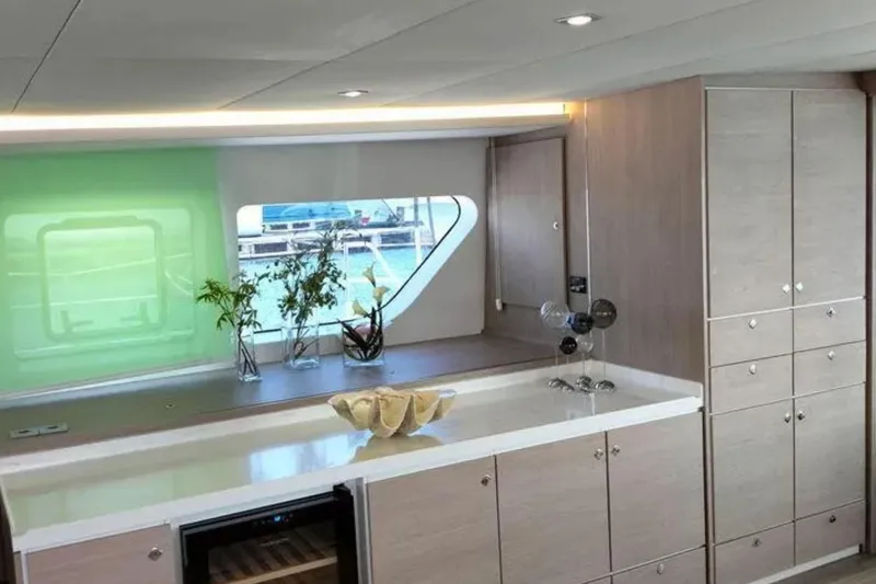  Yacht Photos Pics Modern yacht interior with sleek cabinetry, countertop, and window view. CK70 model, 2023.