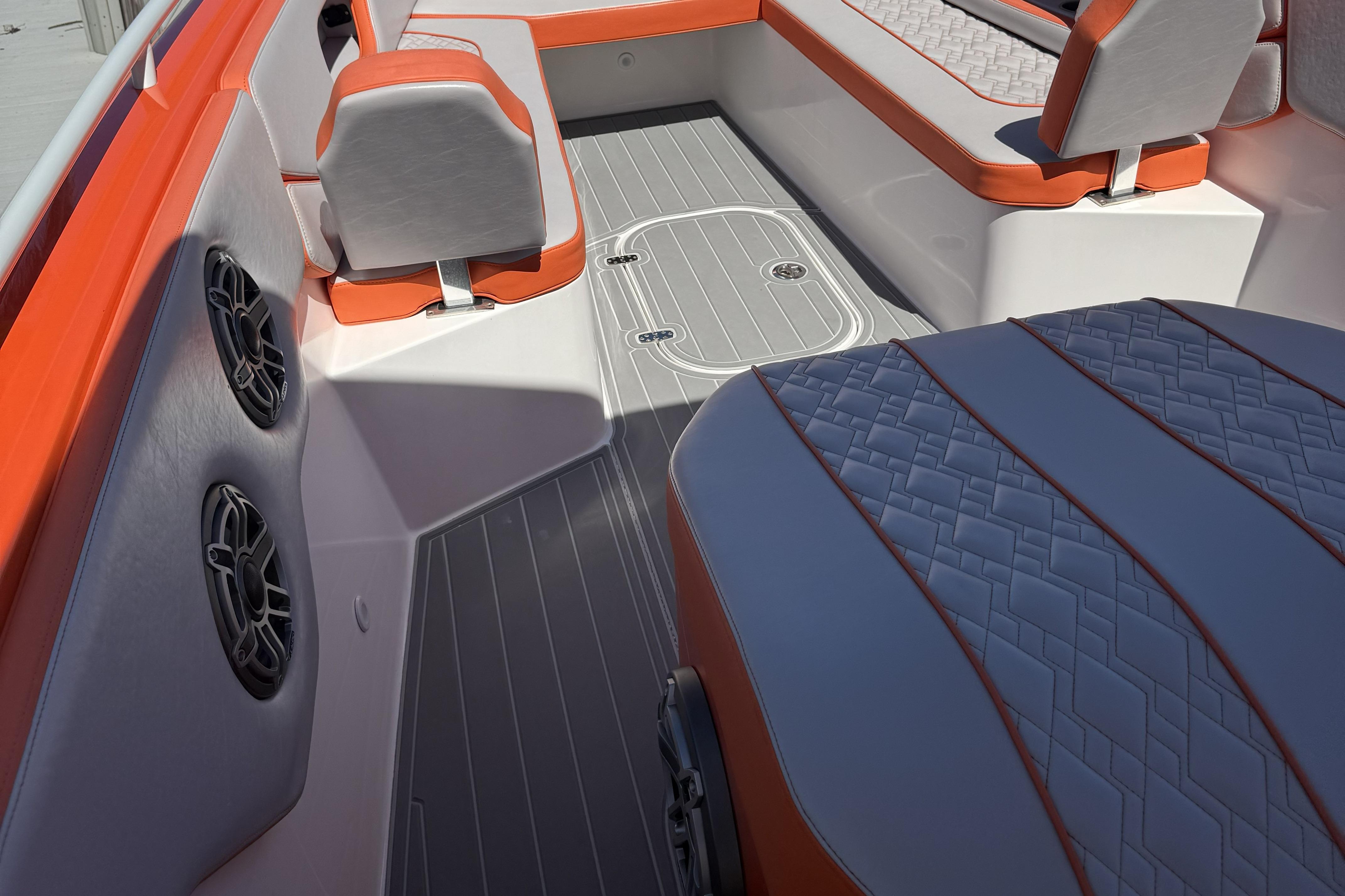Interior of 2025 Concept 32' CC boat with orange and gray seating.