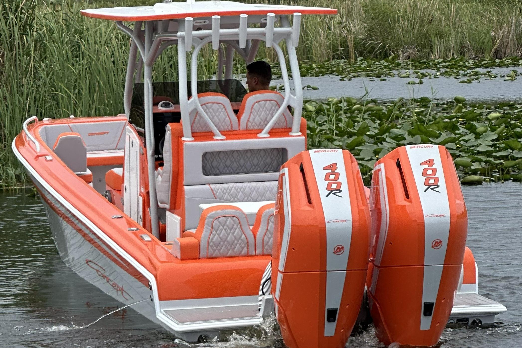 2025 Concept 32' CC boat with dual Mercury 400R engines, vibrant orange and white design.