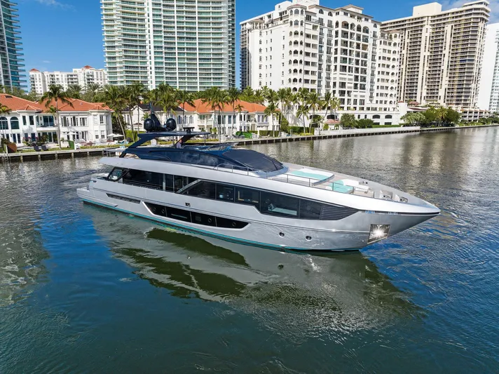 Beso Yacht Photos Pics 2024 Riva 102 Corsaro Super yacht cruising near waterfront buildings.