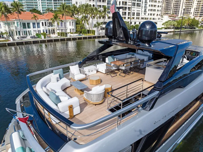 Beso Yacht Photos Pics Luxurious 2024 Riva 102 Corsaro Super yacht with elegant outdoor seating on a scenic waterway.