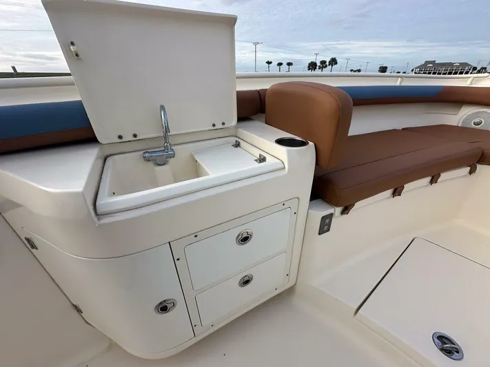 Knot Reel Serious Yacht Photos Pics 2015 Scout 320 LXF boat interior with sink, storage, and seating.