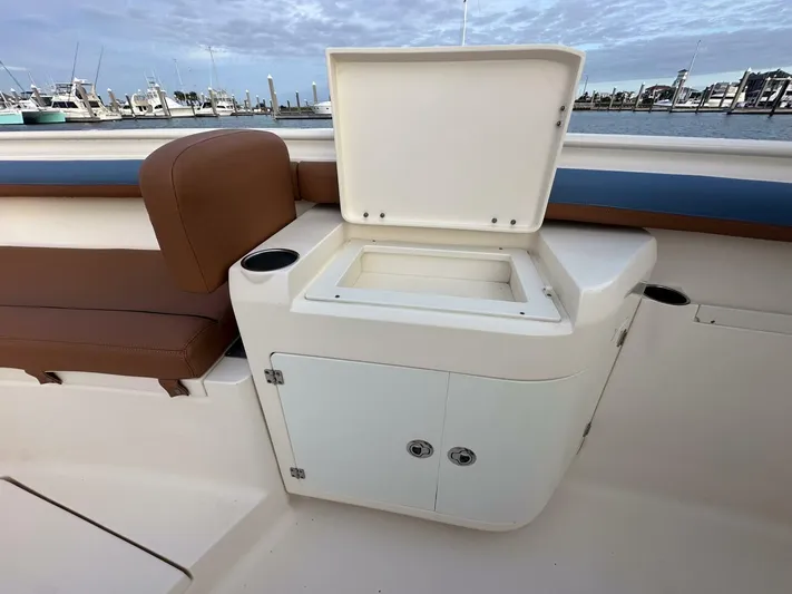 Knot Reel Serious Yacht Photos Pics 2015 Scout 320 LXF boat interior with open storage compartment and brown seating.