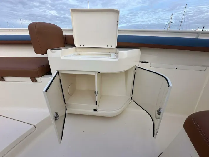Knot Reel Serious Yacht Photos Pics 2015 Scout 320 LXF boat storage compartment with open doors and seat.