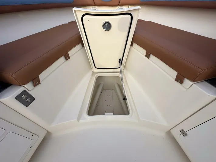 Knot Reel Serious Yacht Photos Pics 2015 Scout 320 LXF boat interior storage compartment with brown seating.