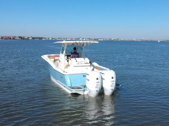 Knot Reel Serious Yacht Photos Pics 2015 Scout 320 LXF boat with twin outboard engines on calm water.