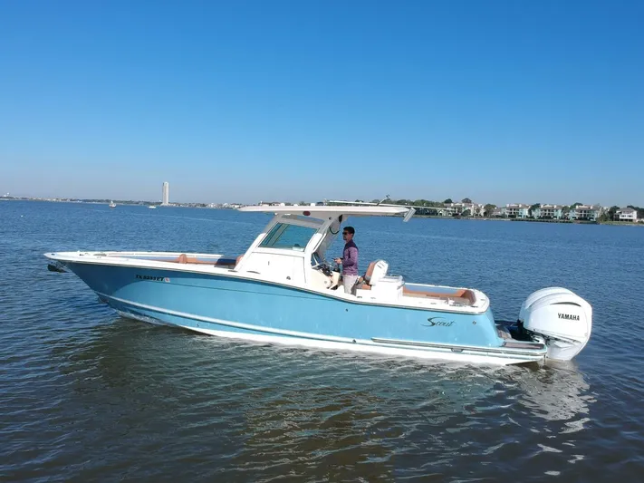 Knot Reel Serious Yacht Photos Pics 2015 Scout 320 LXF boat cruising on a calm waterway.