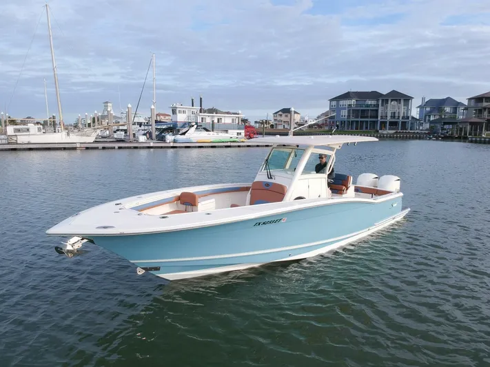 Knot Reel Serious Yacht Photos Pics 2015 Scout 320 LXF boat in a marina with waterfront homes.