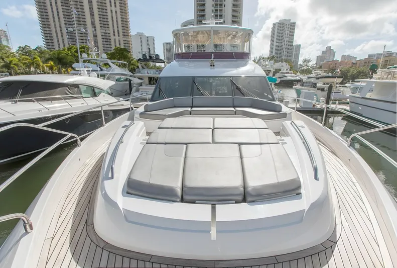 Clarity Yacht Photos Pics 2015 Princess Flybridge 68 Motor Yacht docked in a marina, surrounded by skyscrapers.