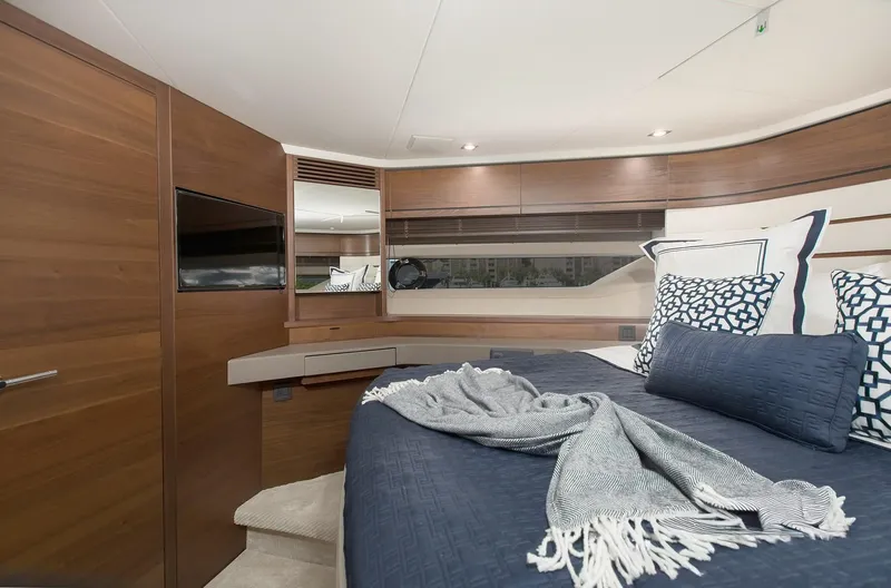 Clarity Yacht Photos Pics Luxurious bedroom interior of 2015 Princess Flybridge 68 Motor Yacht with elegant wood finishes.
