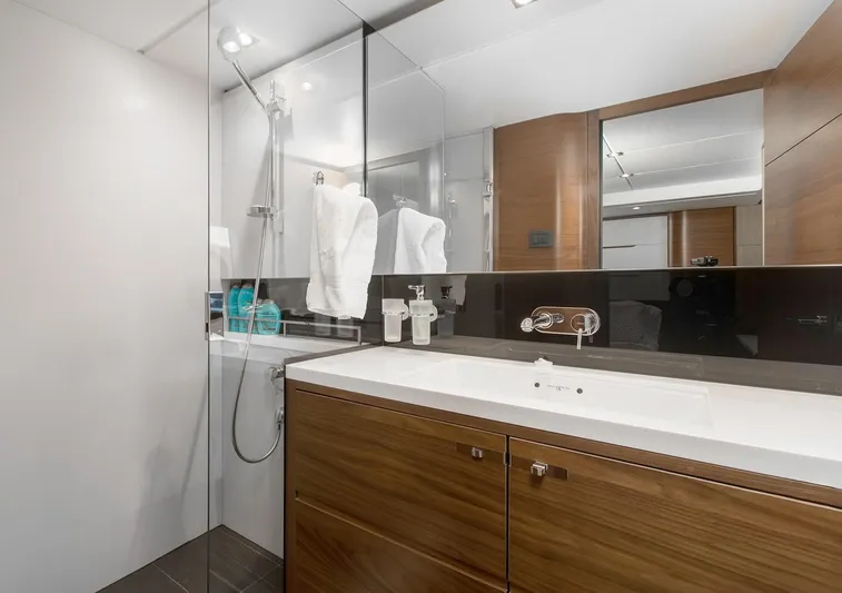 Clarity Yacht Photos Pics Luxurious bathroom on 2015 Princess Flybridge 68 Motor Yacht with modern fixtures and wood accents.