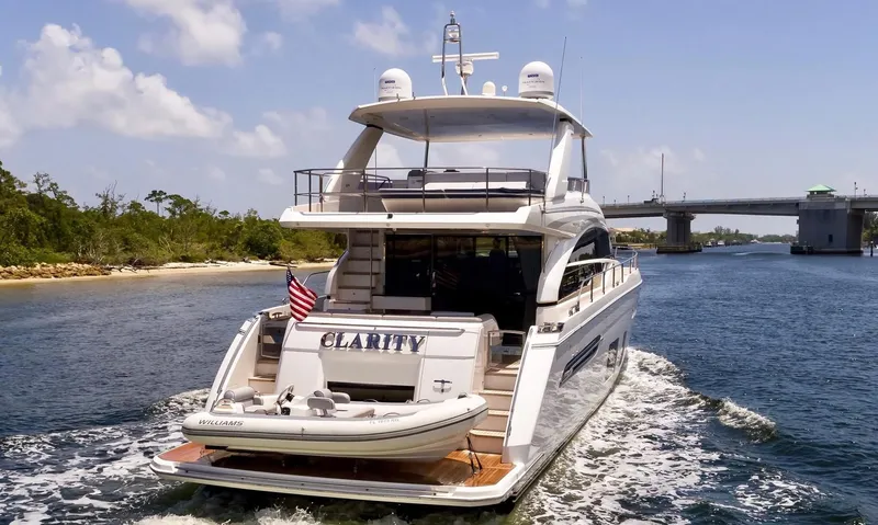 Clarity Yacht Photos Pics 2015 Princess Flybridge 68 Motor Yacht cruising near a bridge on a sunny day.