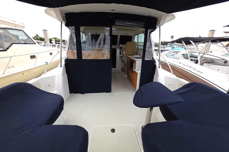Jubilee Yacht Photos Pics 2018 Back Cove 32 boat interior with navy seating and covered cockpit at marina.