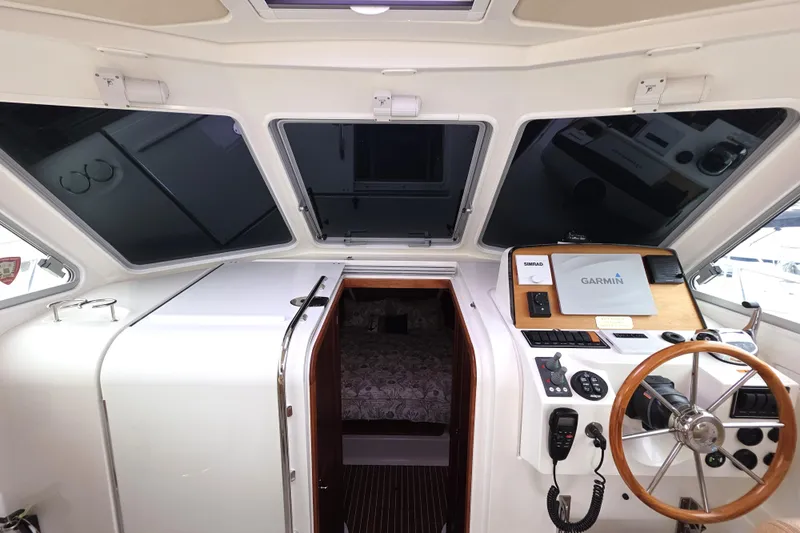 Jubilee Yacht Photos Pics 2018 Back Cove 32 helm with Garmin navigation, wooden steering wheel, and cabin entrance.