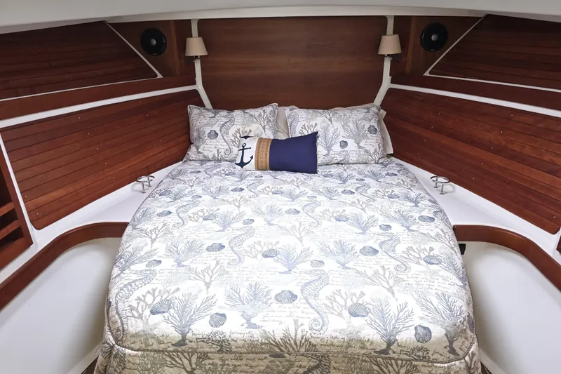 Jubilee Yacht Photos Pics Cozy cabin interior of 2018 Back Cove 32 with nautical-themed bedding and wooden accents.