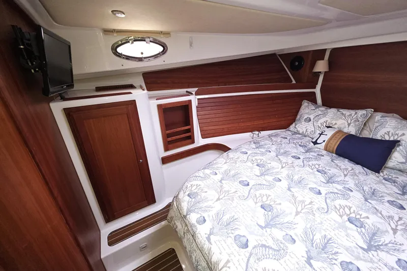 Jubilee Yacht Photos Pics 2018 Back Cove 32 cabin interior with cozy bed, wooden accents, and nautical decor.