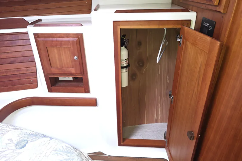 Jubilee Yacht Photos Pics 2018 Back Cove 32 interior with wooden cabinetry and open closet showing fire extinguisher.
