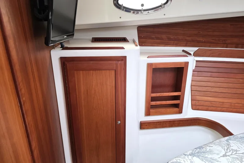 Jubilee Yacht Photos Pics 2018 Back Cove 32 interior with wooden cabinetry and mounted TV.