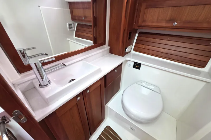 Jubilee Yacht Photos Pics 2018 Back Cove 32 yacht bathroom with wooden cabinetry and modern fixtures.
