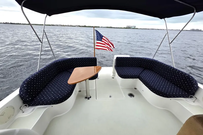 Jubilee Yacht Photos Pics 2018 Back Cove 32 boat deck with seating, table, and American flag on the water.