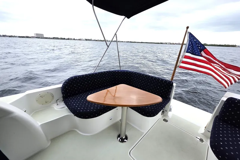 Jubilee Yacht Photos Pics 2018 Back Cove 32 boat with seating area, triangular table, and American flag on open water.