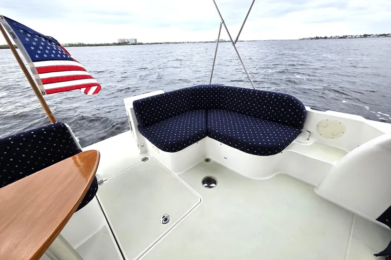 Jubilee Yacht Photos Pics 2018 Back Cove 32 boat with cushioned seating and American flag on open water.