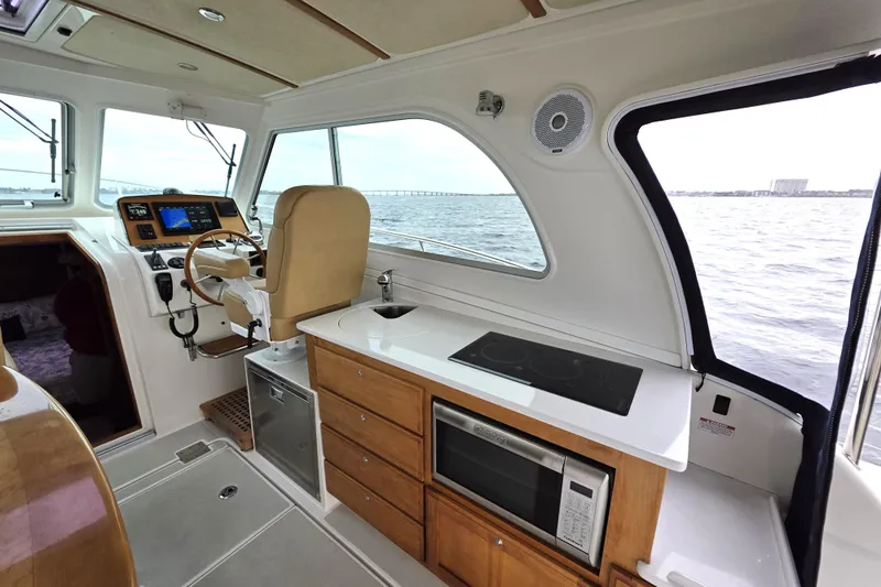 Jubilee Yacht Photos Pics Interior of 2018 Back Cove 32 boat with helm, kitchen, and ocean view.