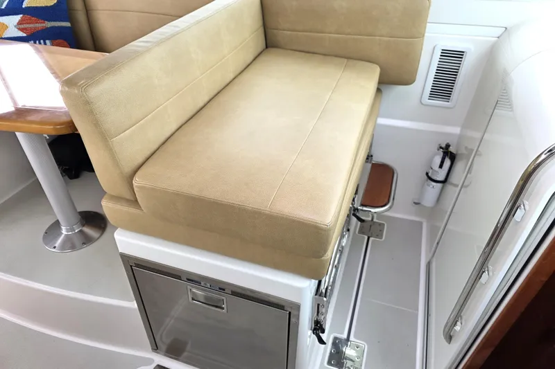 Jubilee Yacht Photos Pics 2018 Back Cove 32 interior with beige seating and compact kitchenette.