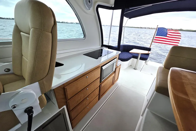 Jubilee Yacht Photos Pics 2018 Back Cove 32 yacht interior with kitchen, seating, and American flag.