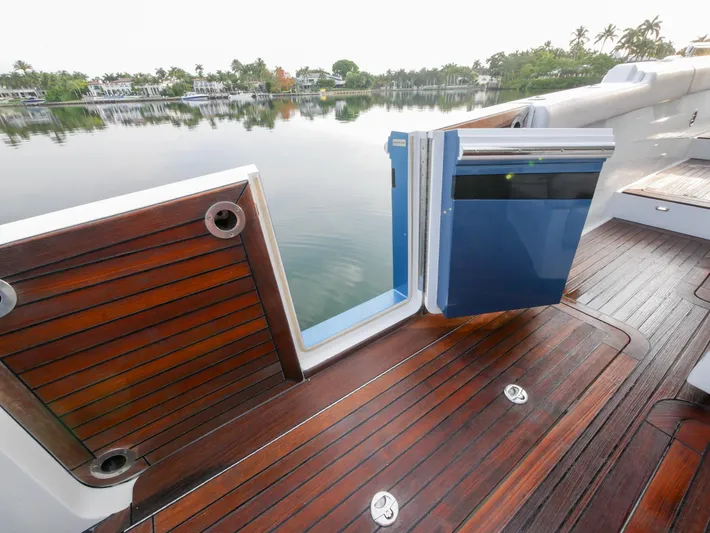 Low Hours Yacht Photos Pics 2020 Ocean Alexander 45 Divergence Sport yacht with open side door, wooden deck, and serene water view.
