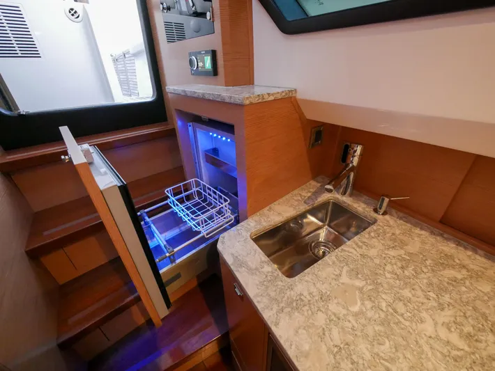 Low Hours Yacht Photos Pics 2020 Ocean Alexander 45 Divergence Sport yacht interior with sink and open mini fridge.