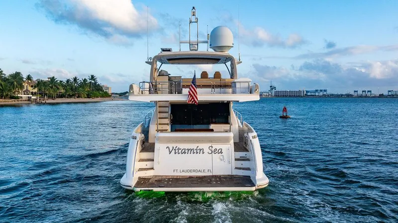 Vitamin Sea Yacht Photos Pics Azimut 70 Fly 2011 yacht cruising on open water, rear view with American flag.