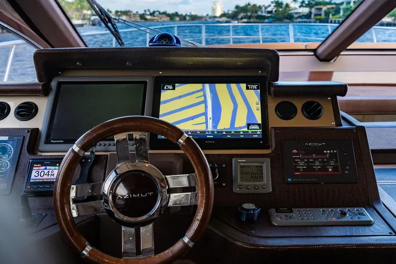 Vitamin Sea Yacht Photos Pics Cockpit of 2011 Azimut 70 Fly yacht with navigation screens and steering wheel.